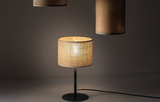 Jute table lamp on a table with two jute pendant lights hanging above, photographed in a studio setting