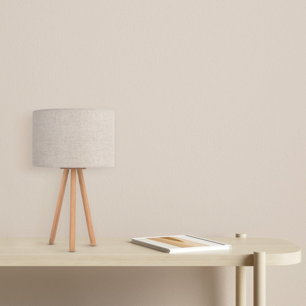 TOKYO tripod table lamp with a natural linen shade on light wood legs, shown on a nightstand