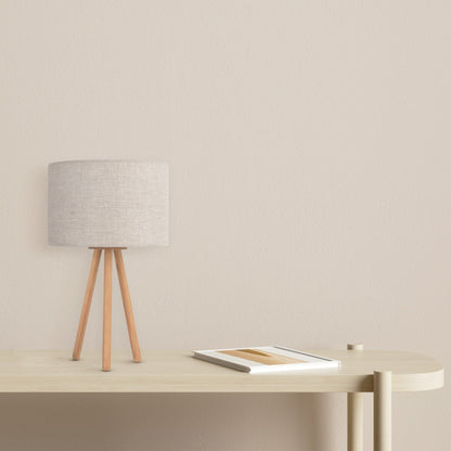 TOKYO tripod table lamp with a natural linen shade on light wood legs, shown on a nightstand