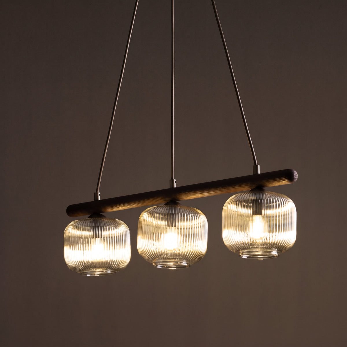 SALVIA linear pendant above a kitchen island with wood and stone